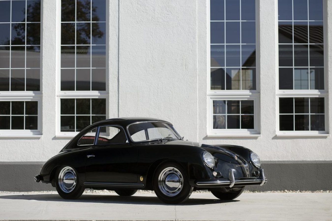 Porsche 356 in schwarz vor Gebäude