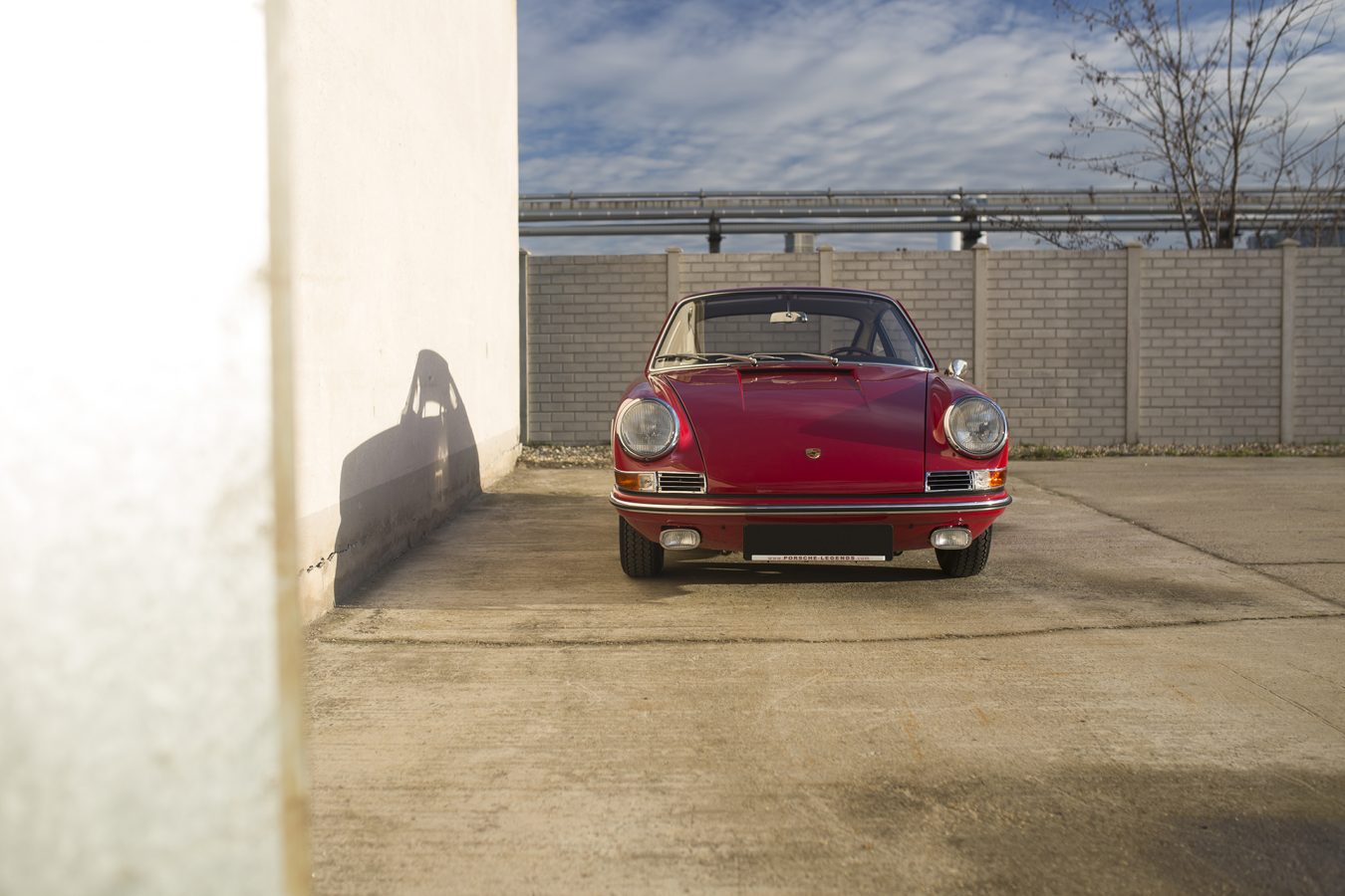 Roter Porsche 911 vor einer Mauer