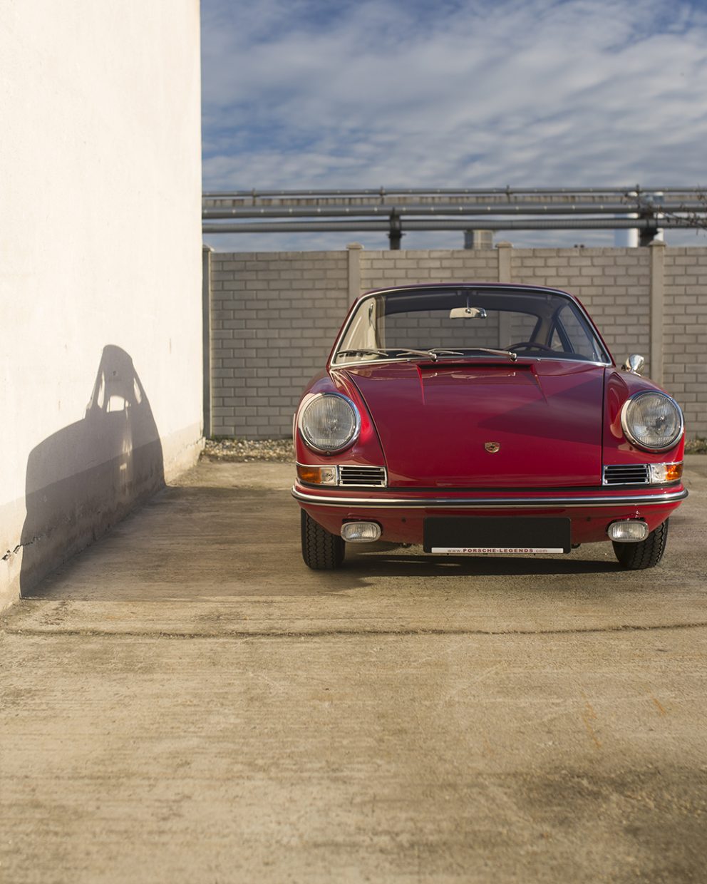 Roter Porsche 911 vor einer Mauer