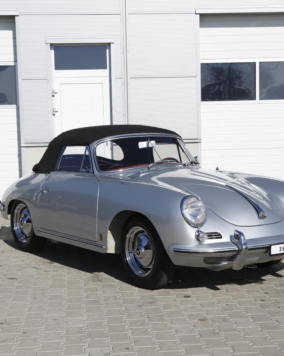 Silberner Porsche 356 BT6 Cabrio vor Garage