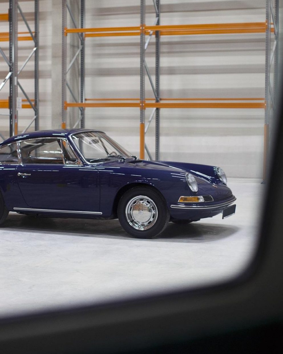 Blauer von der Seite Porsche 911 SWB vor Lagerregalen